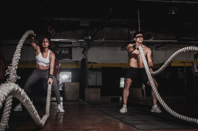 Persona entrenando con pesas en un gimnasio con ropa deportiva de dos piezas